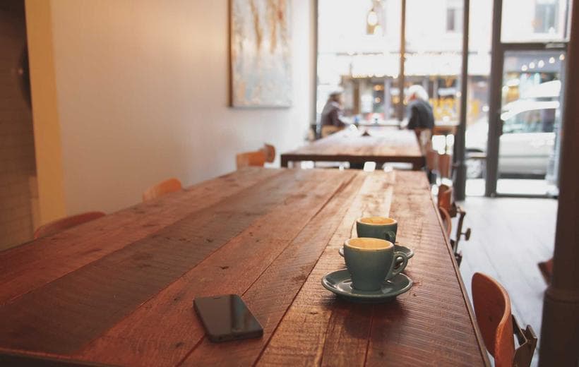 The inside of a small shop, with a long communal table running through it.